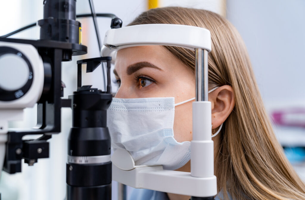 Women with mask undergoing eye exam at eye doctors office