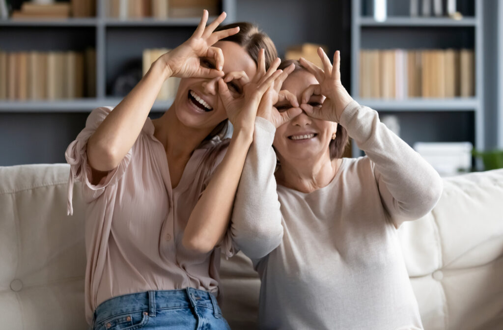 Daughter and mother portraying healthy vision after undergoing vision therapy by making circles around their eyes