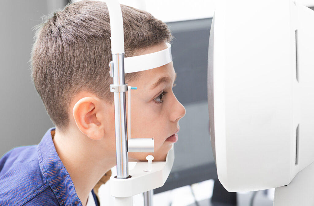 A close-up of a young male patient looking through an auto-refractor to determine the refractive error of his eyes.