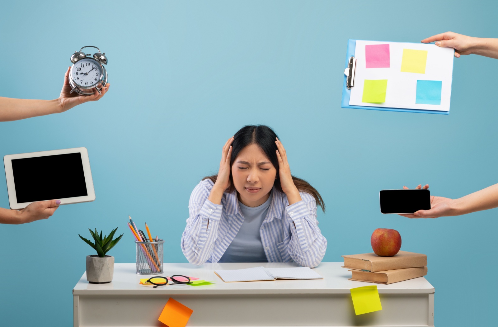 A stressed, young adult gripping their head at the thought of missing deadlines.