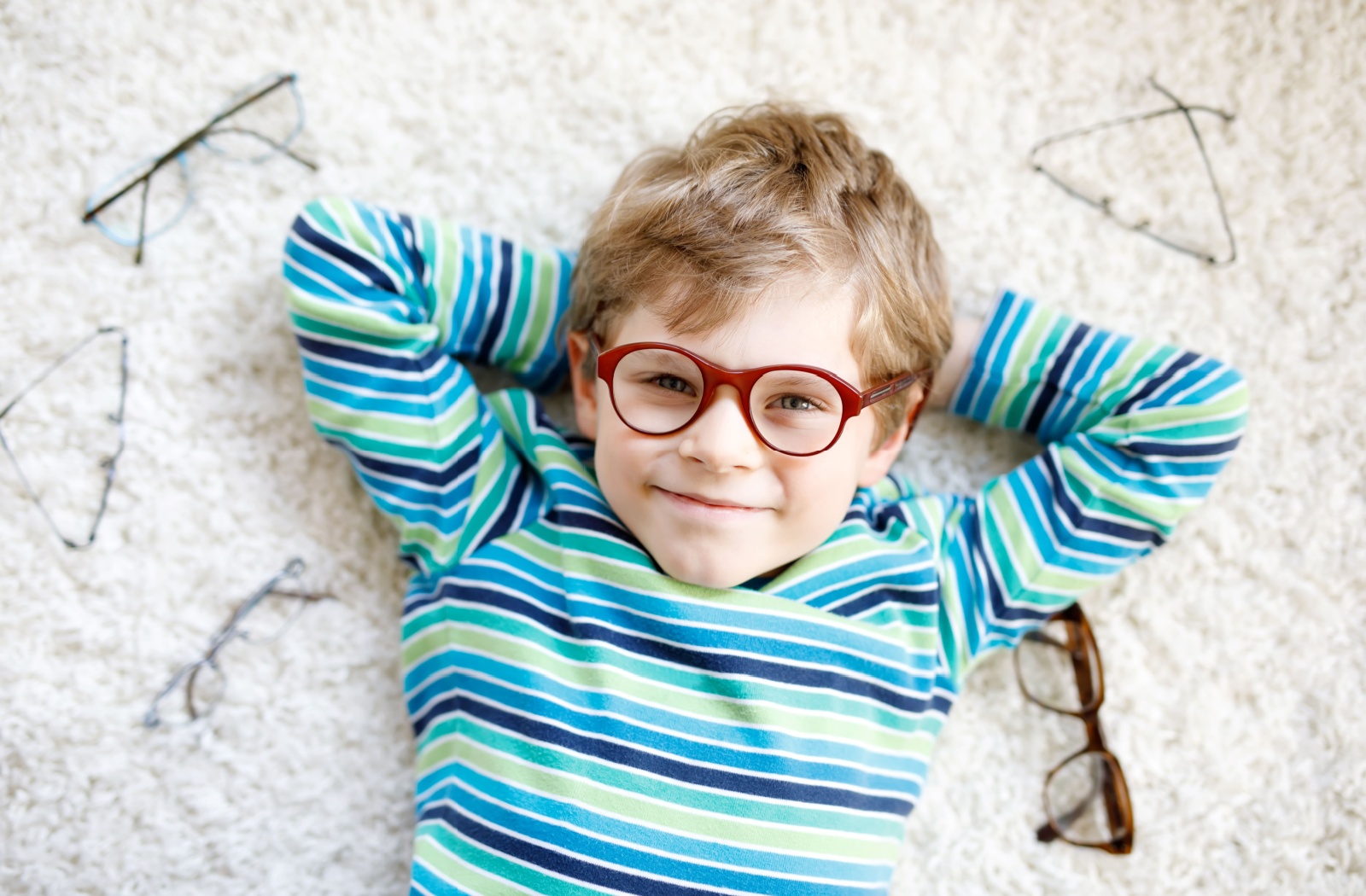 A young child wearing glasses, demonstrating the importance of choosing the right eyewear for kids and myopia control.
