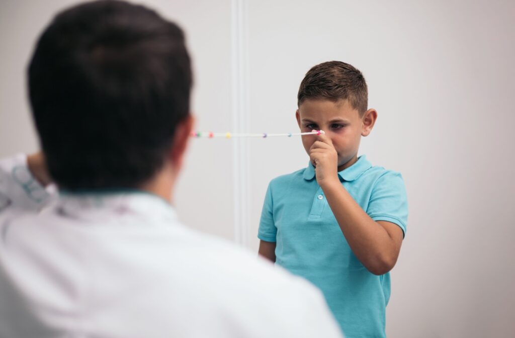 A child holding and focusing on a string during a vision therapy session to help with proper eye alignment.